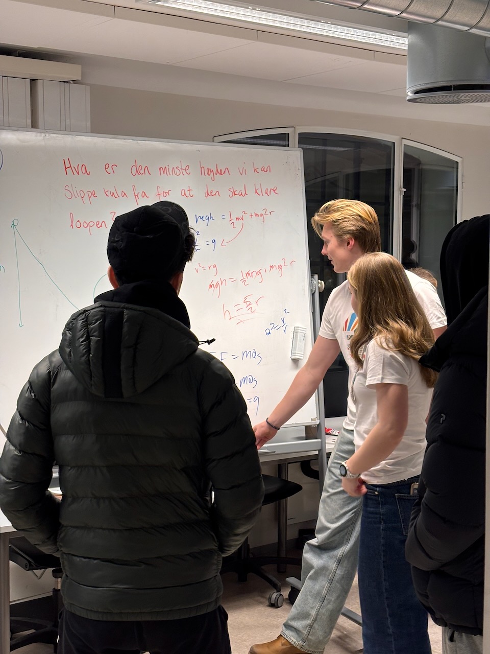 En gruppe mennesker som står foran en whiteboard