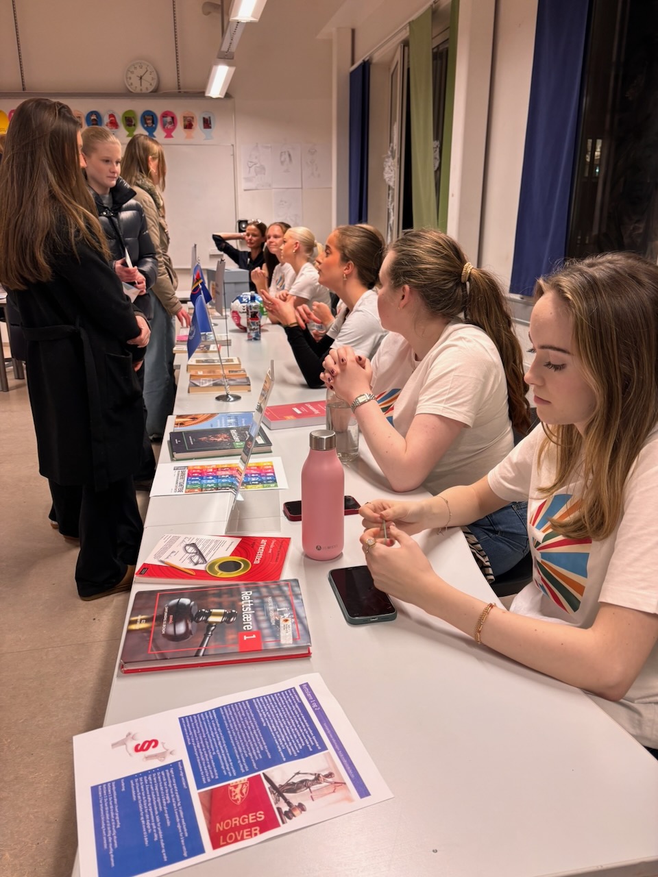En gruppe mennesker som sitter ved et bord med et spillebrett