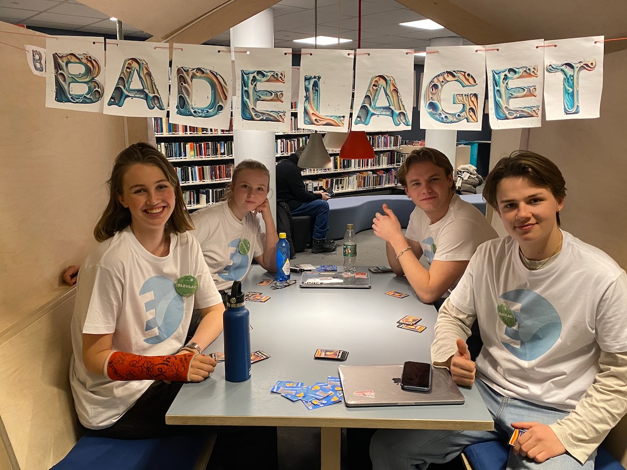 En gruppe mennesker som sitter ved et bord og poserer for kameraet