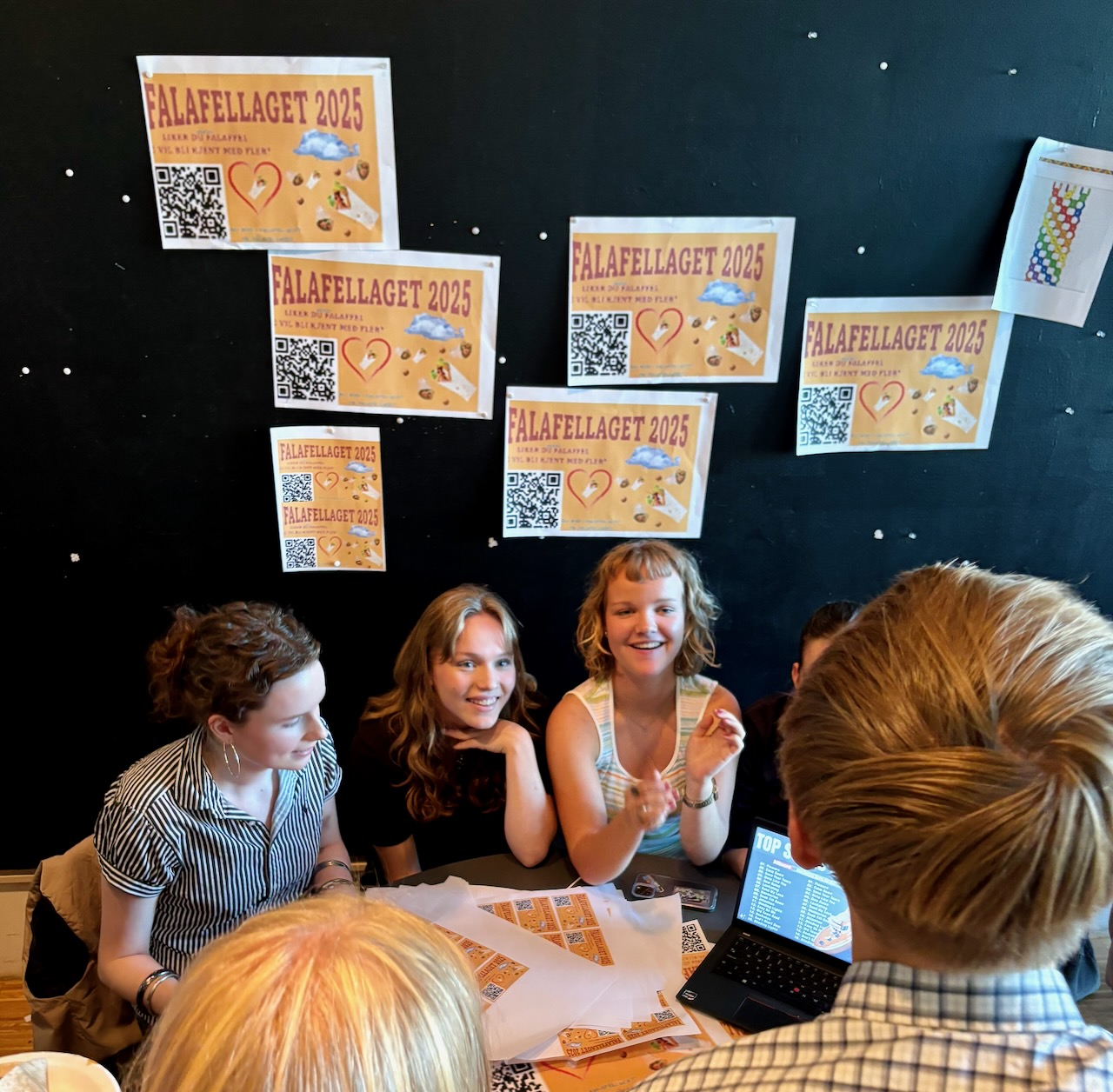 en gruppe mennesker som sitter ved et bord med papirer på