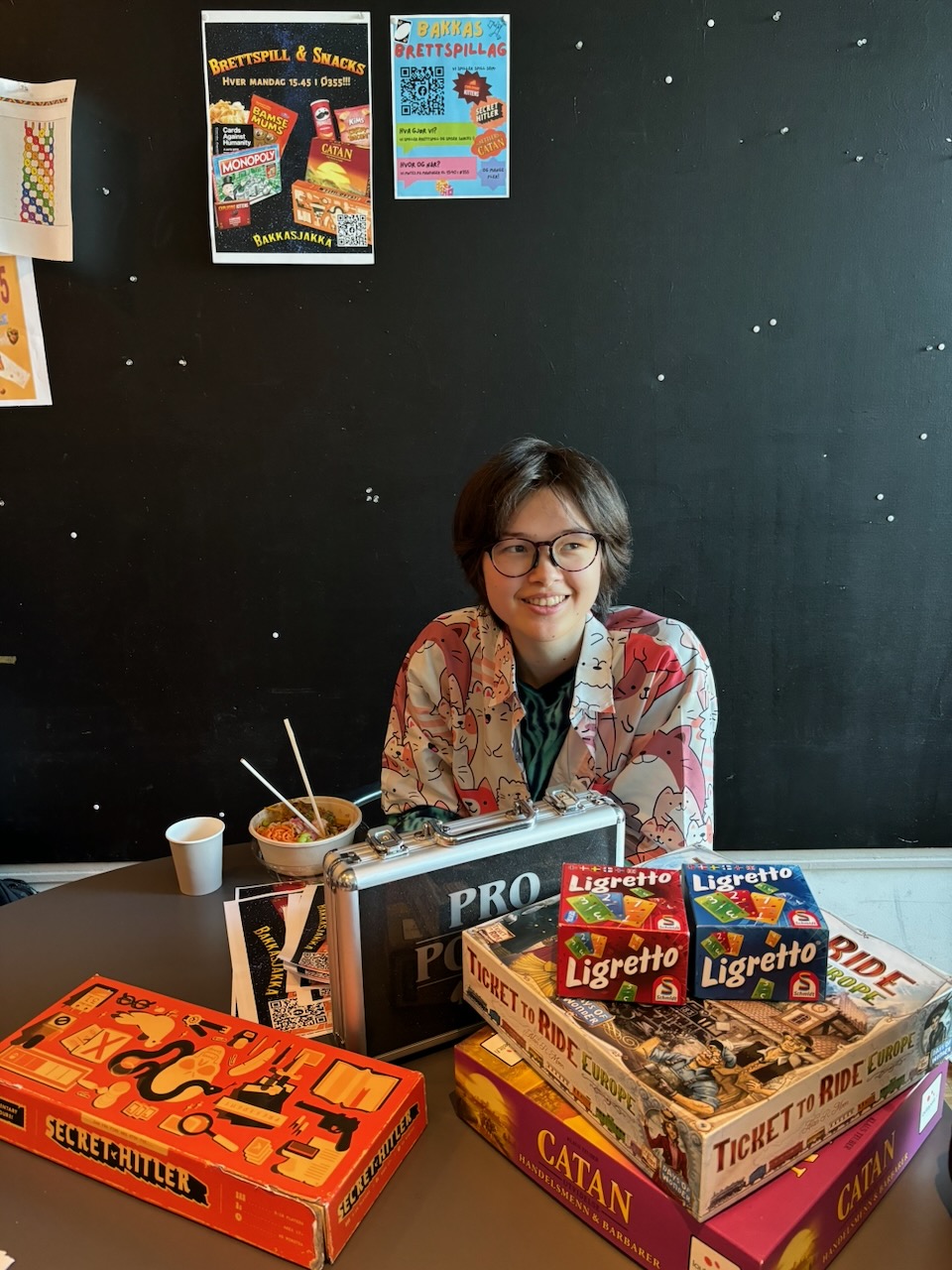 En person som sitter ved et bord med esker full av mat