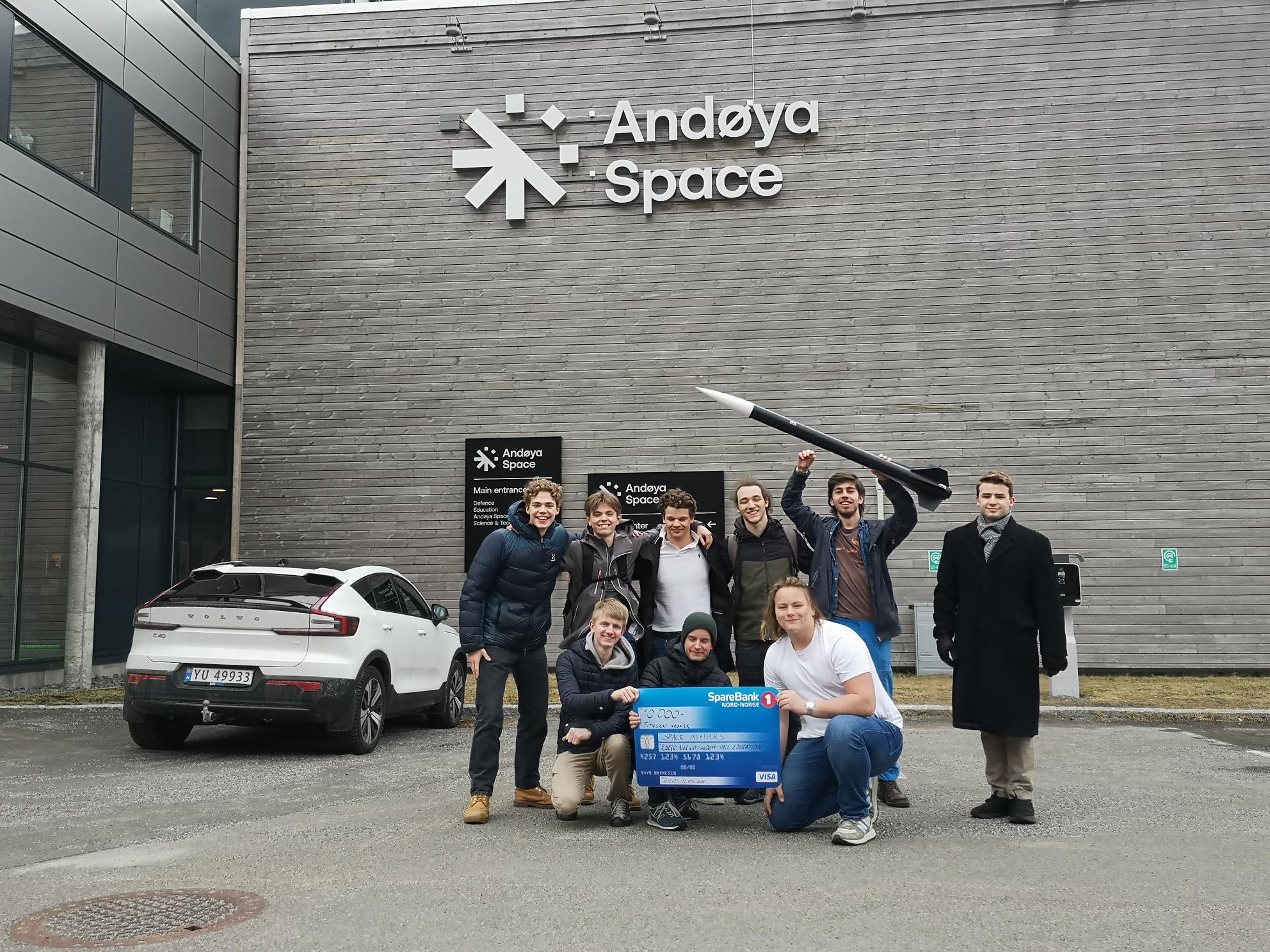 en gruppe mennesker som poserer for et bilde foran en bygning