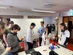 en gruppe mennesker som står rundt et bord med en tavle
