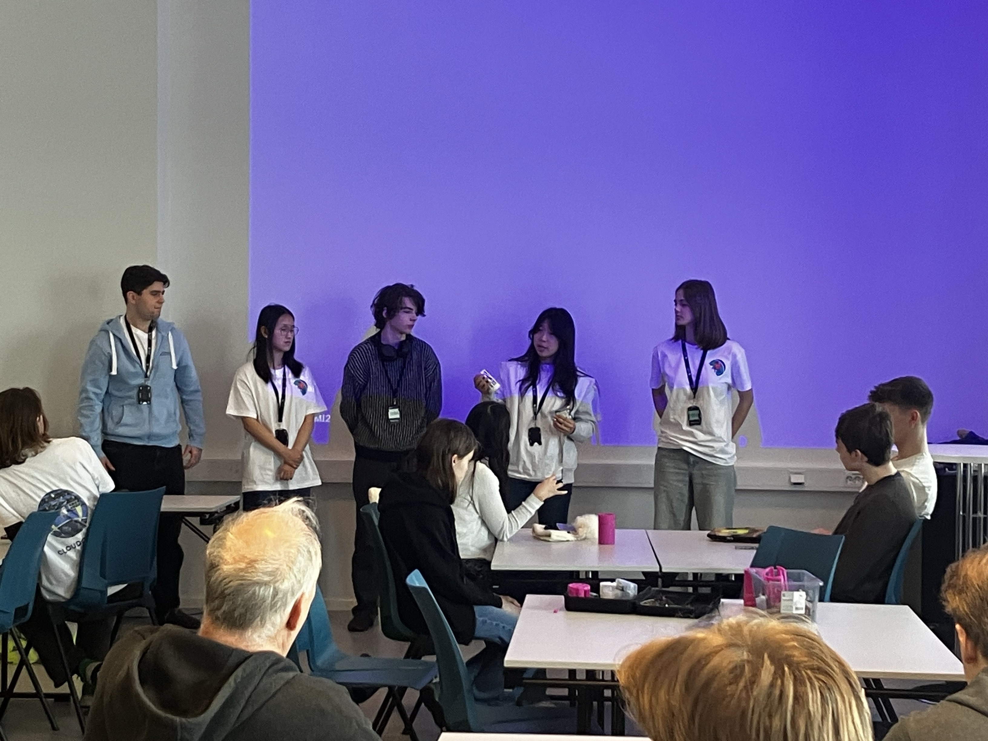 en gruppe mennesker som står foran en skjerm