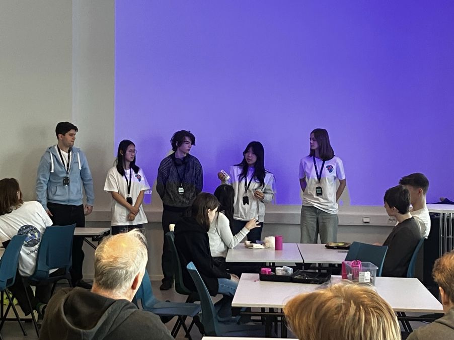 en gruppe mennesker som står foran en skjerm