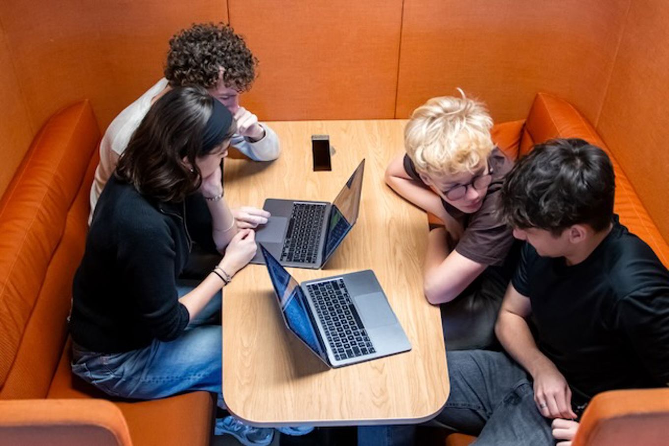 en gruppe mennesker som sitter rundt et bord og ser på en bærbar datamaskin en gruppe mennesker som sitter rundt et bord og ser på en bærbar datamaskin