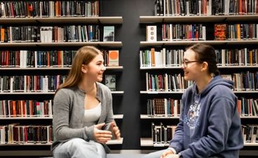 noen få personr som sitter i et bibliotek