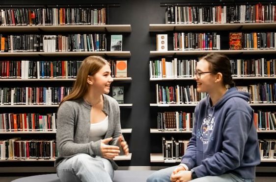 noen få personr som sitter i et bibliotek