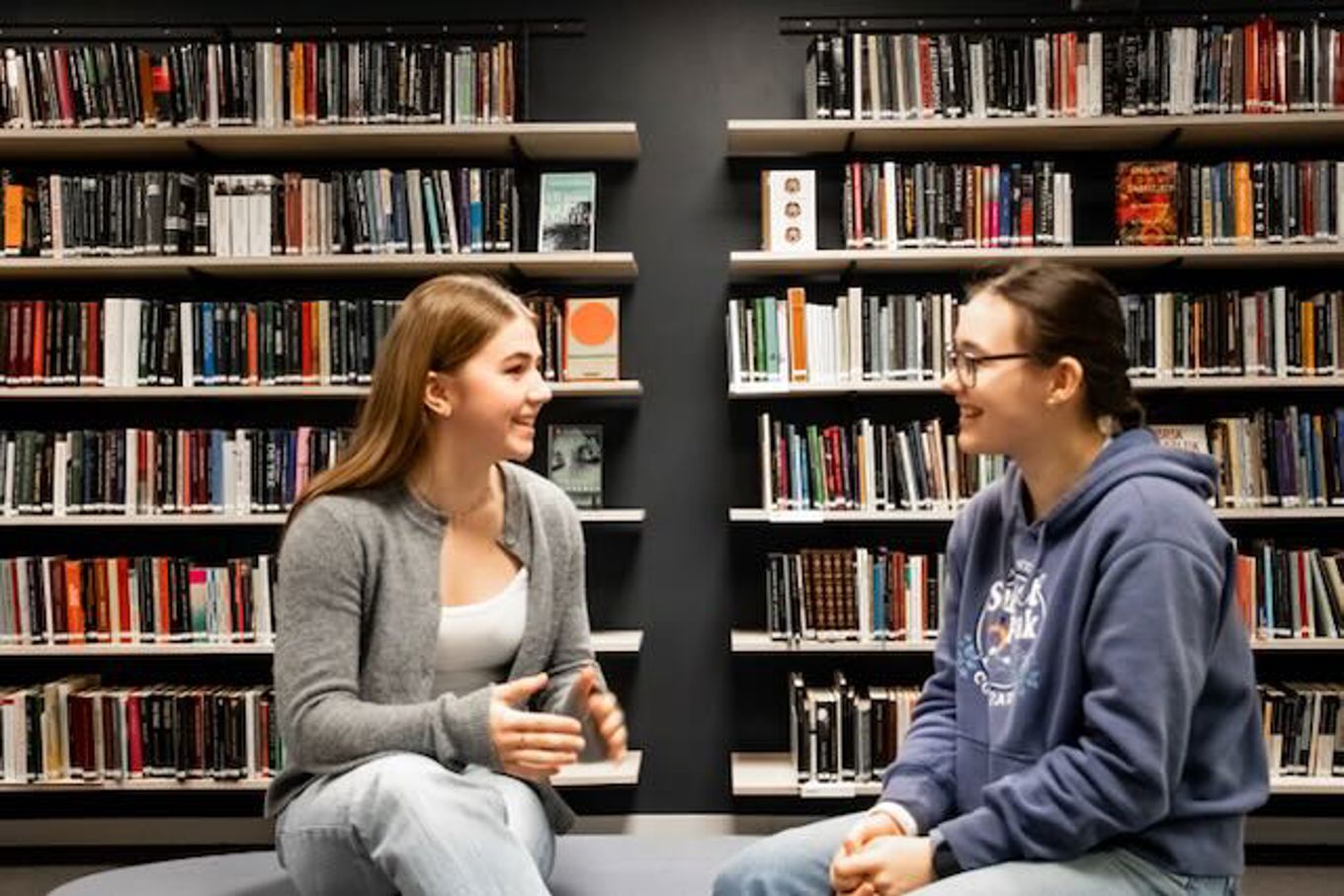 noen få personr som sitter i et bibliotek