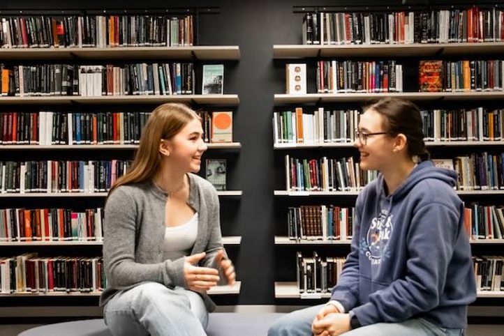 noen få personr som sitter i et bibliotek