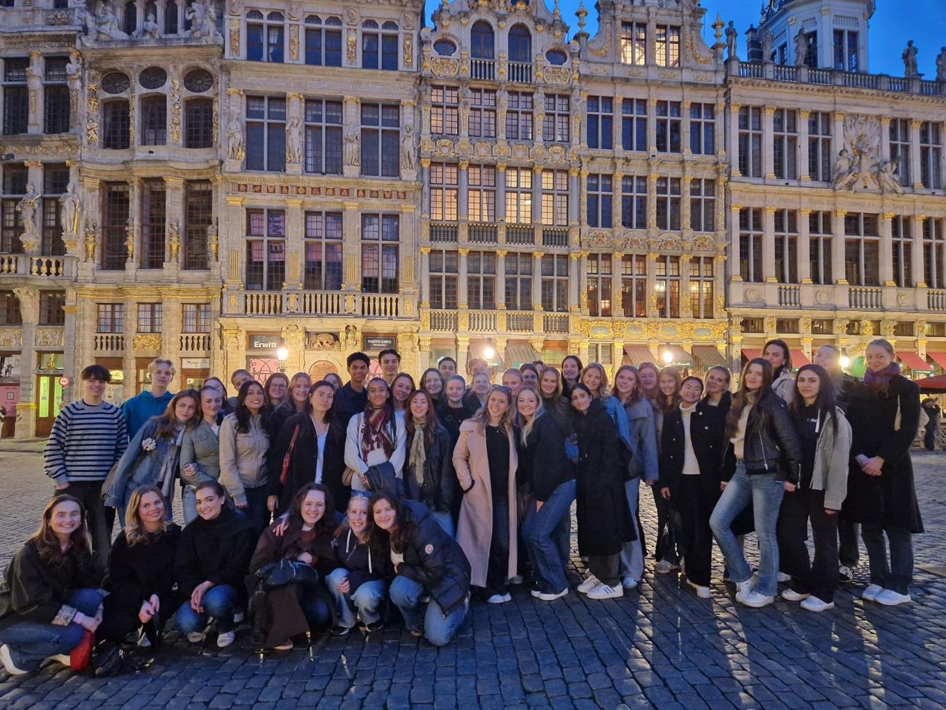 en gruppe mennesker som poserer for et bilde foran en bygning