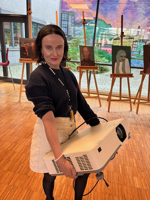 en person som sitter på en stol og holder en bærbar datamaskin