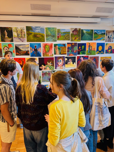 en gruppe mennesker som ser på bilder på en vegg