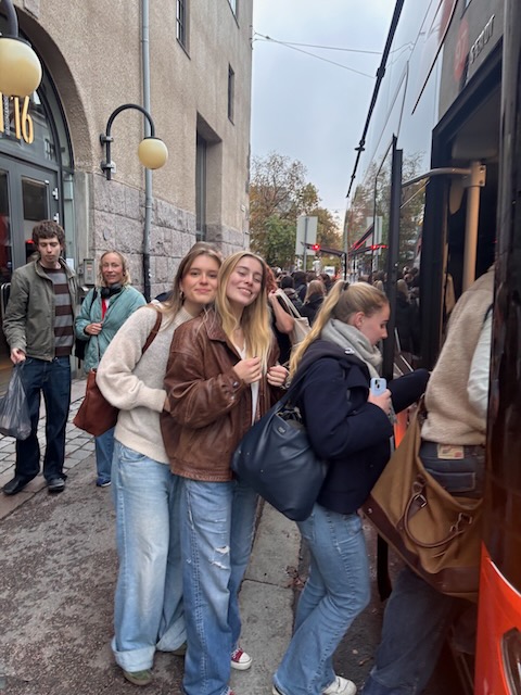 en gruppe mennesker som står på et fortau