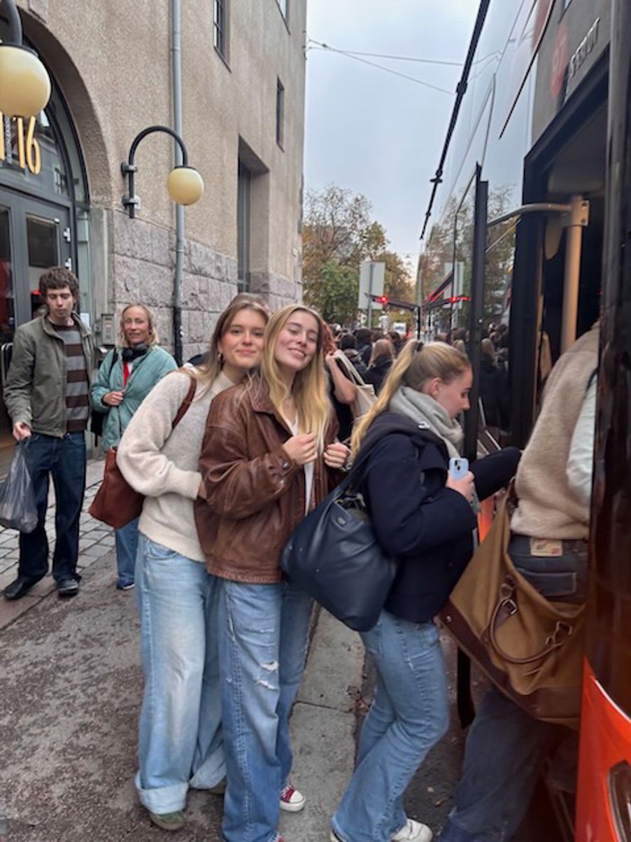 en gruppe mennesker som står på et fortau