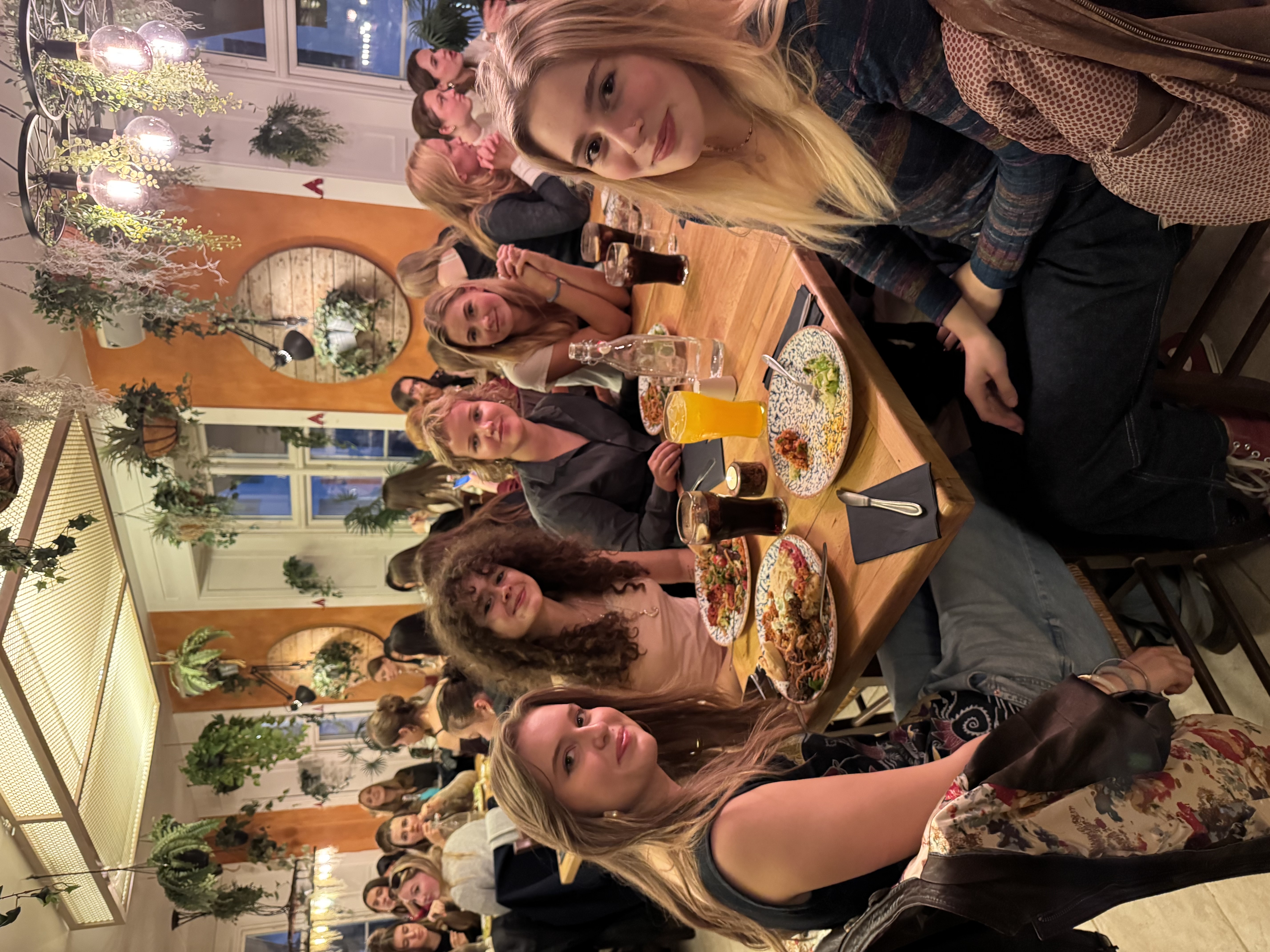 en gruppe personr som sitter ved et bord med mat