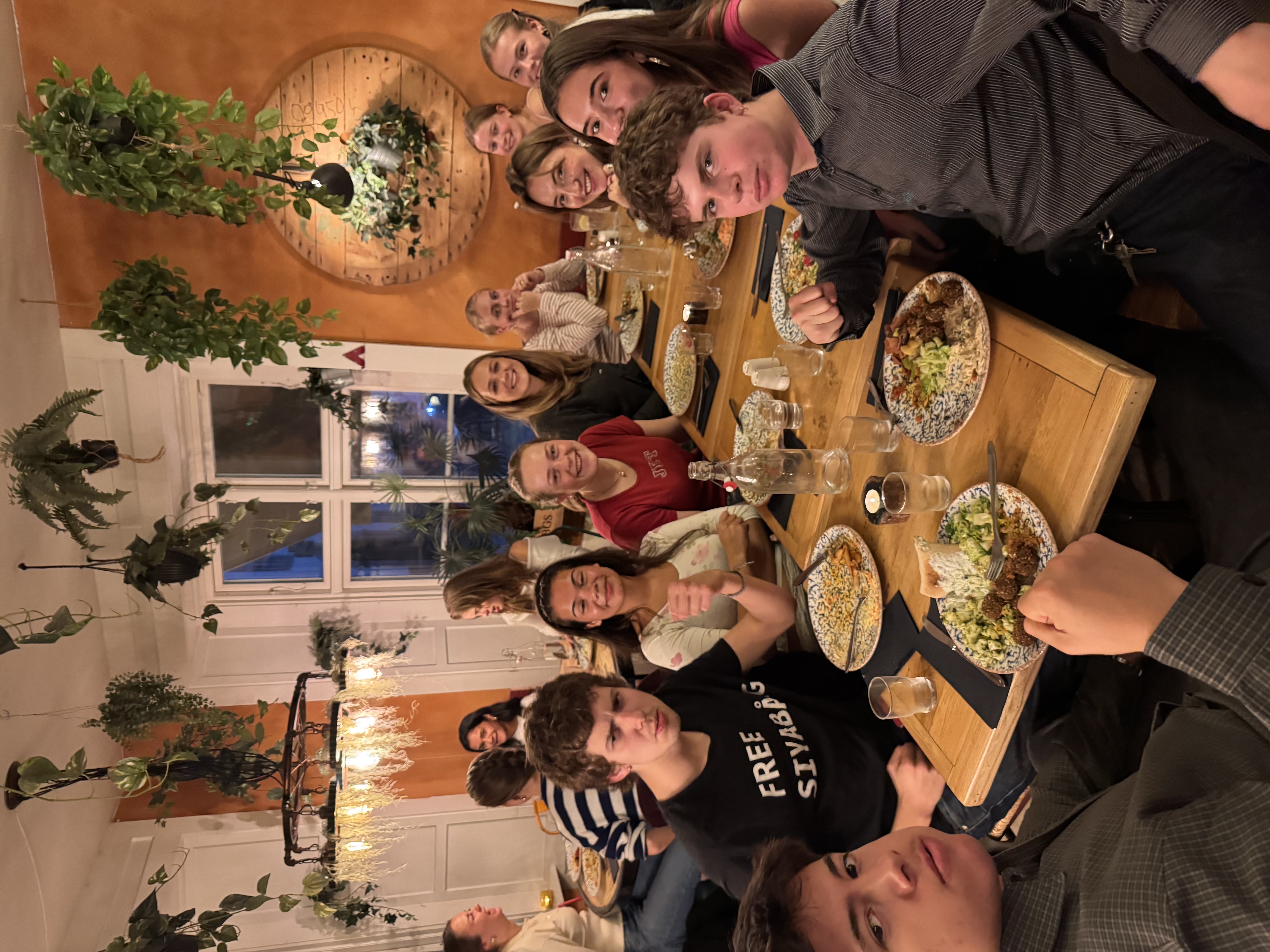 en gruppe mennesker som sitter rundt et bord med mat