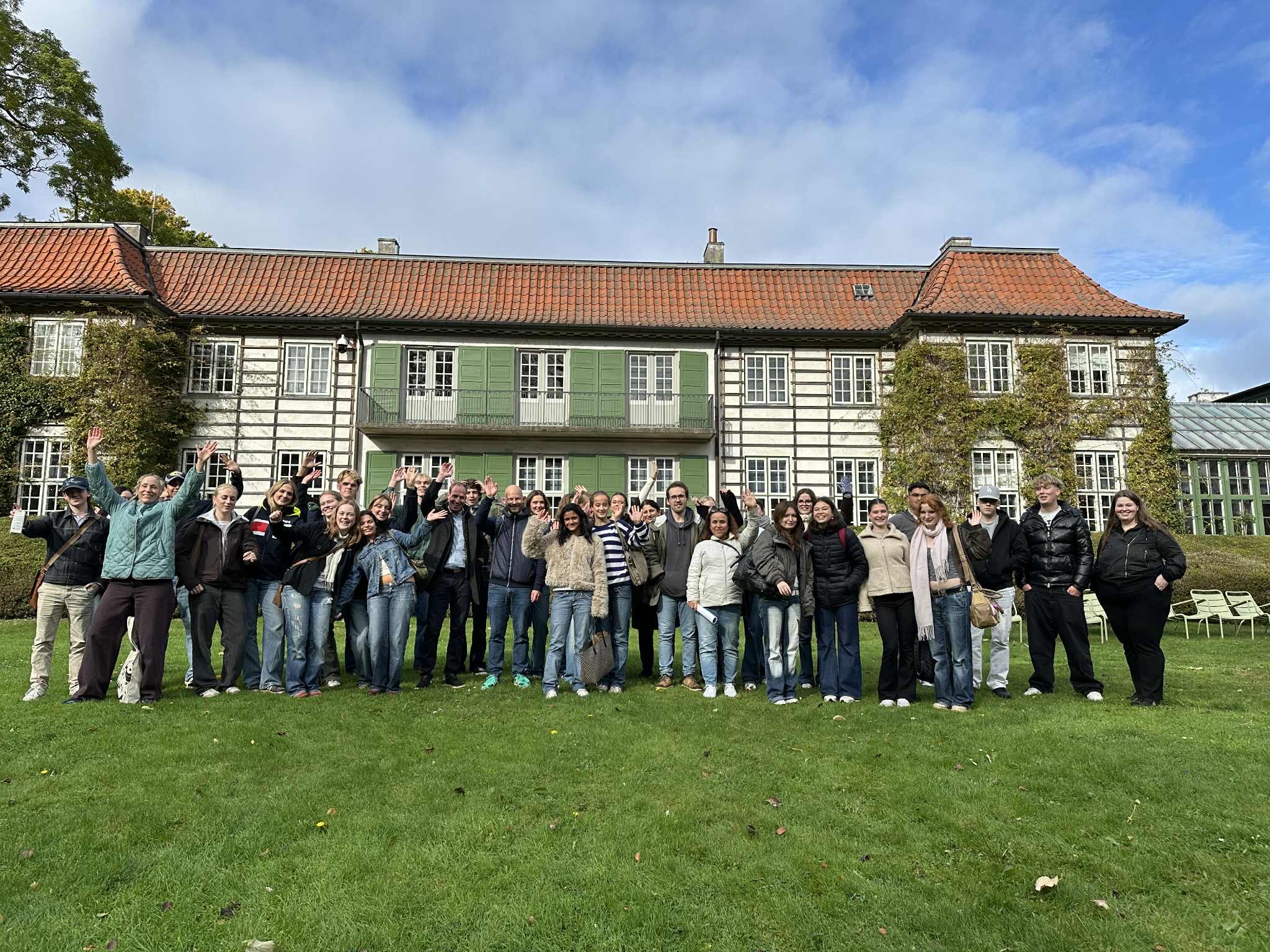 en gruppe mennesker som poserer for et bilde foran en bygning