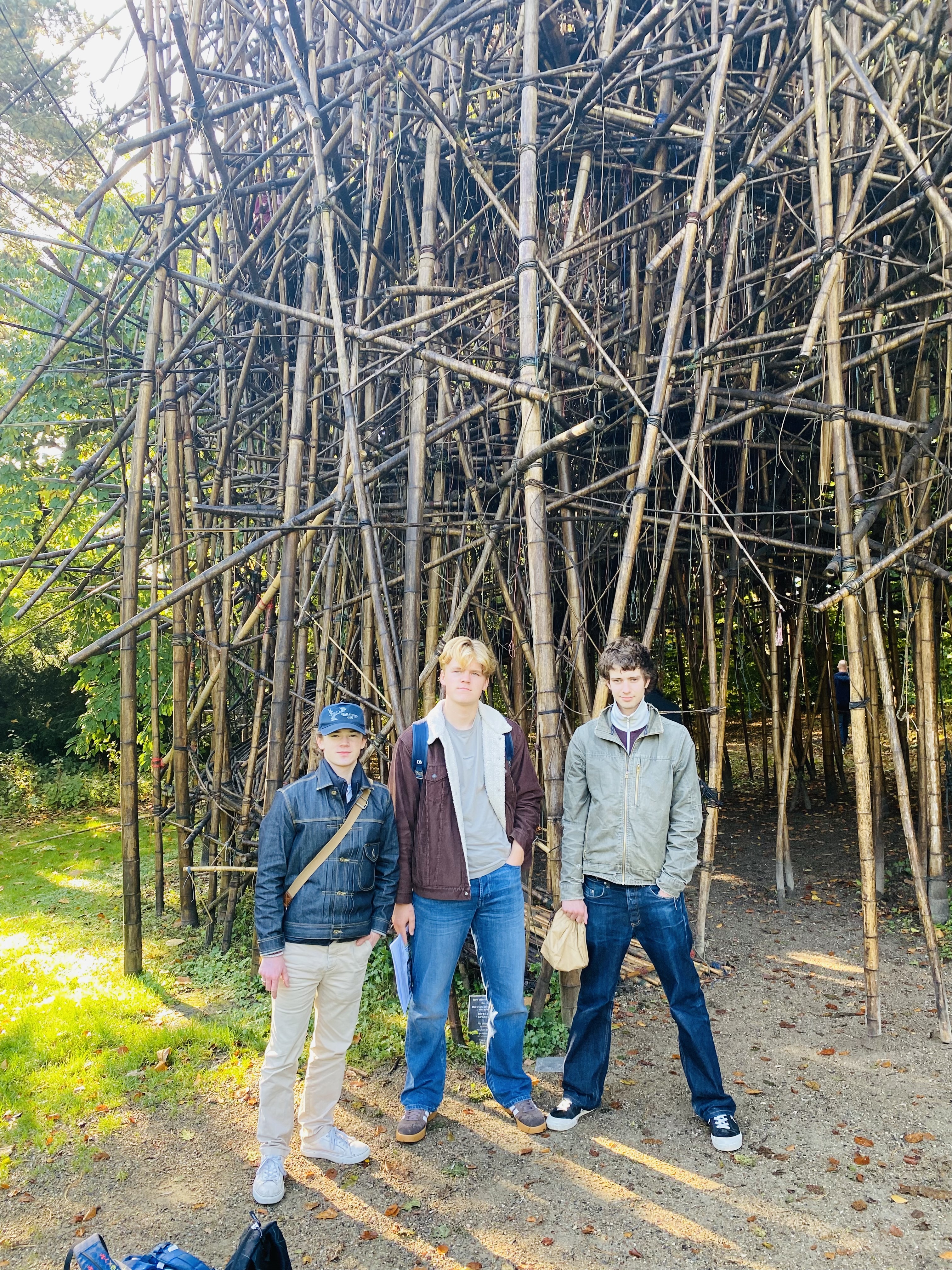 en gruppe mennesker som står foran en rad med bambustrær
