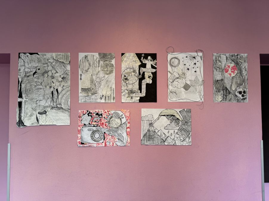 En gruppe tegninger på en rosa vegg