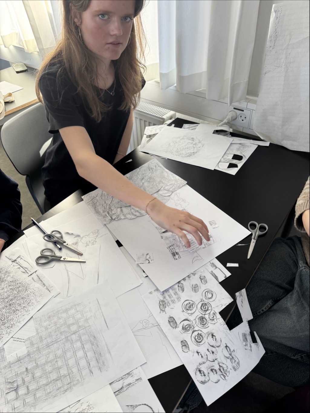 en person som sitter ved et bord med en tegning på