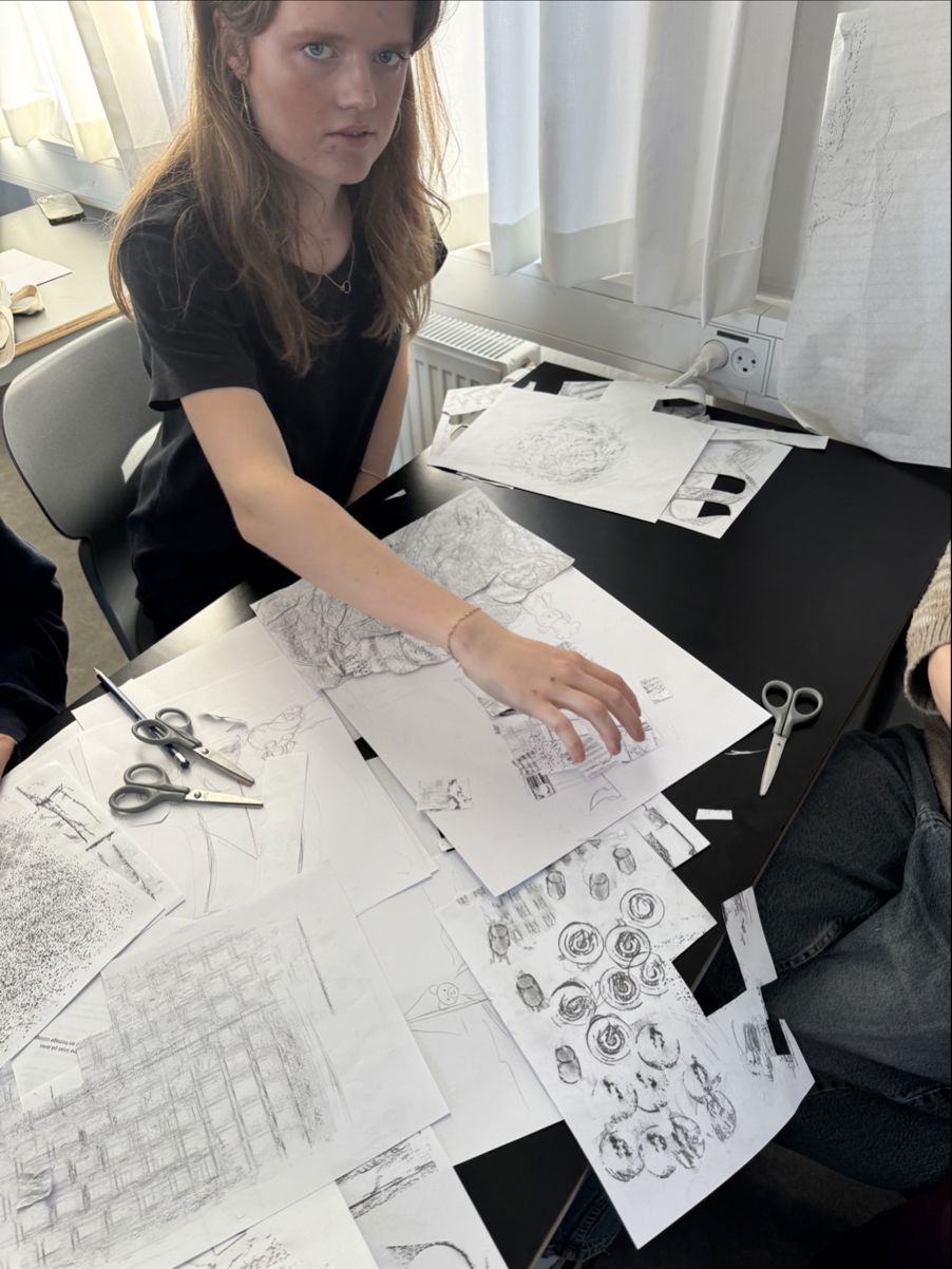 en person som sitter ved et bord med en tegning på