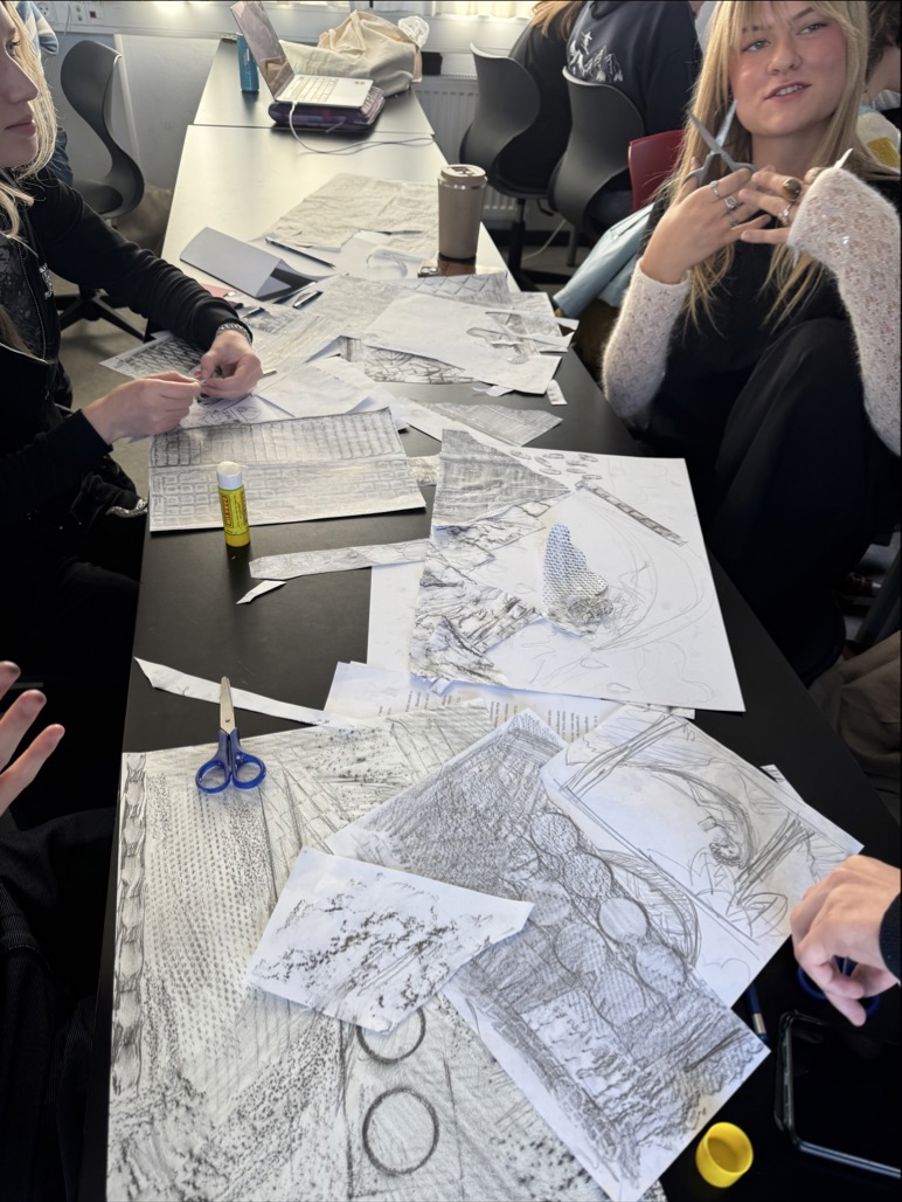 en gruppe mennesker som sitter ved et bord med tegninger på