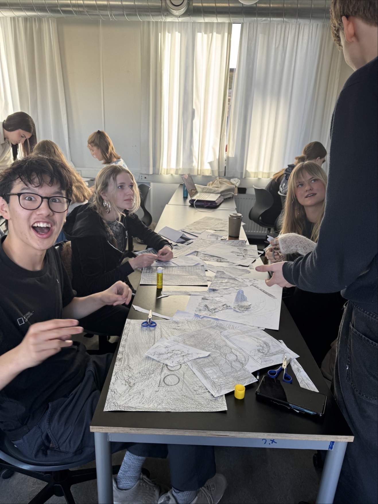 en gruppe mennesker som sitter rundt et bord med en tegning på