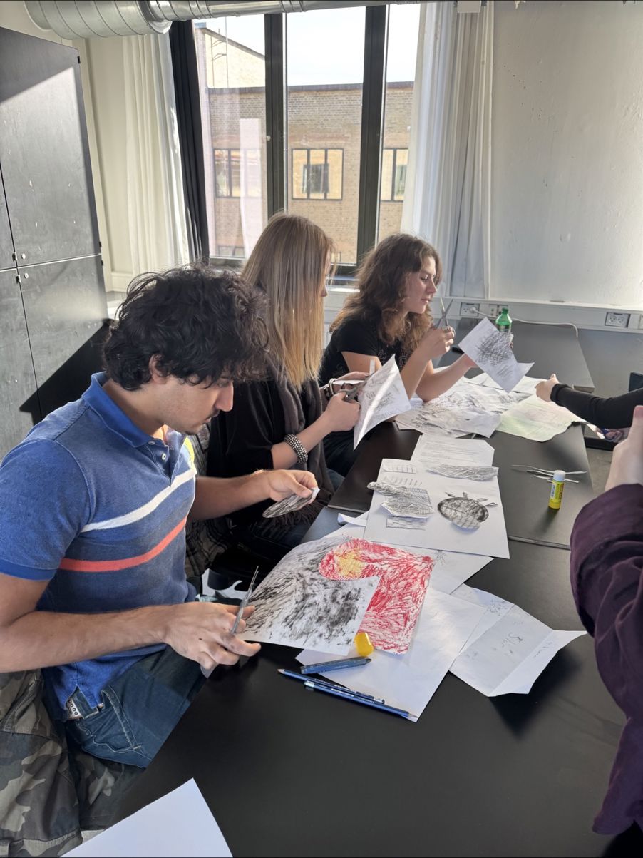 en gruppe mennesker som sitter ved et bord og spiser pizza