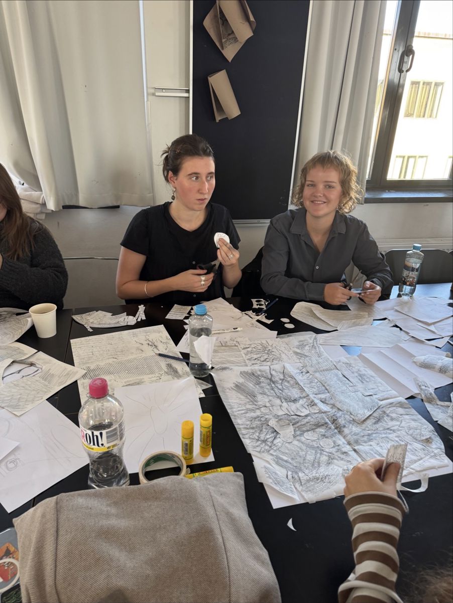 et par personr som sitter ved et bord med papirer og vannflasker