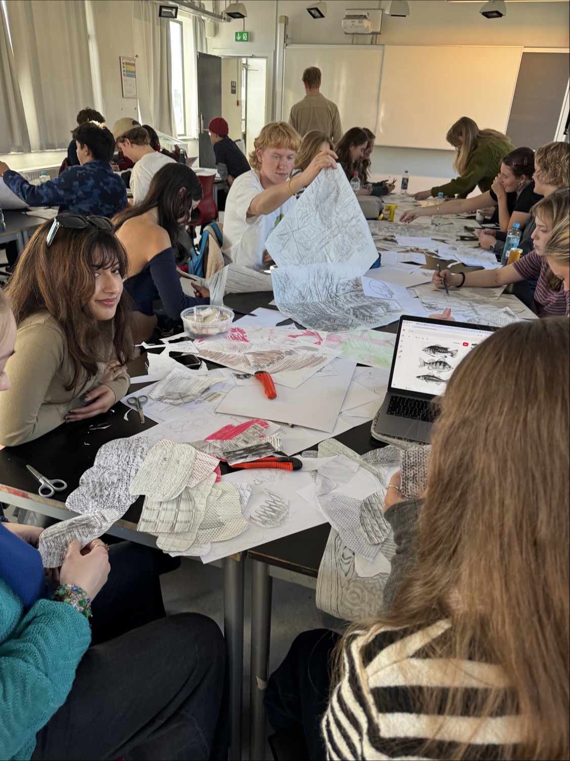 en gruppe mennesker som sitter ved et bord med en person i en hvit kjole