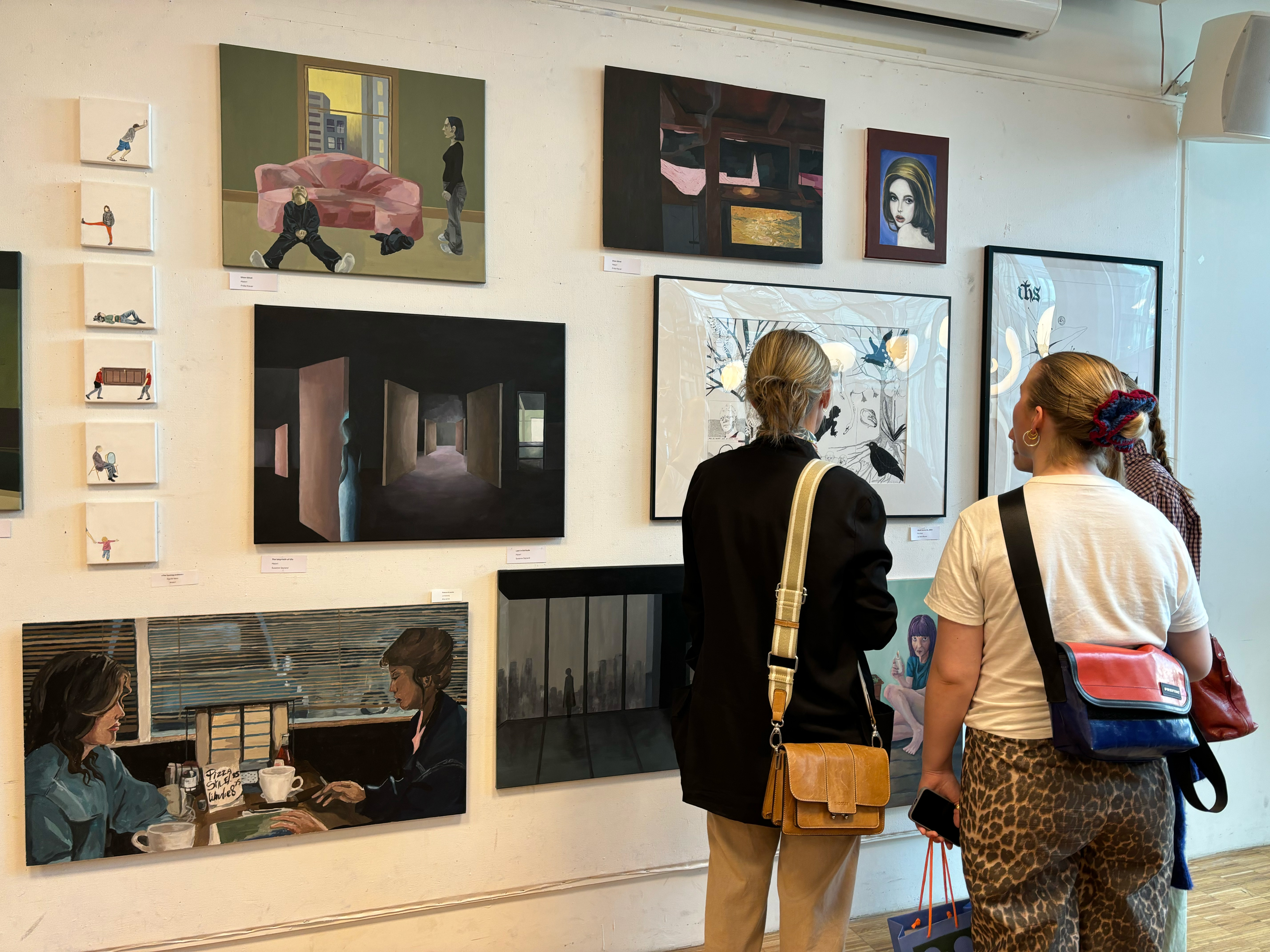 et par personr som ser på bilder på en vegg