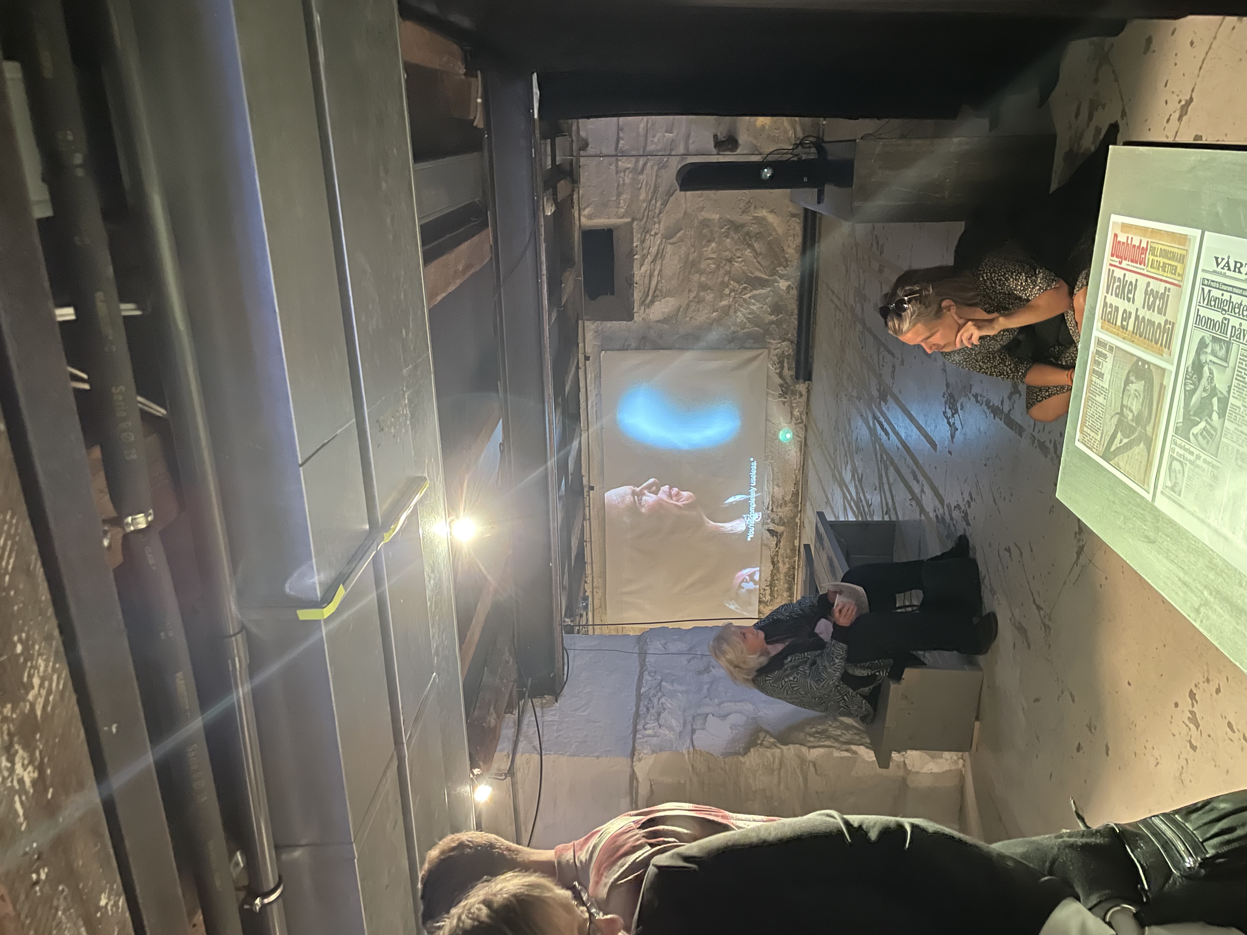 en gruppe mennesker som sitter i et rom med en projektorskjerm