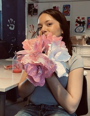 en person som holder en stor rosa blomst