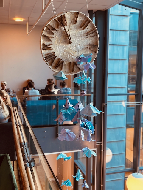 en gruppe mennesker som sitter ved et bord med blå og hvite papirsommerfugler