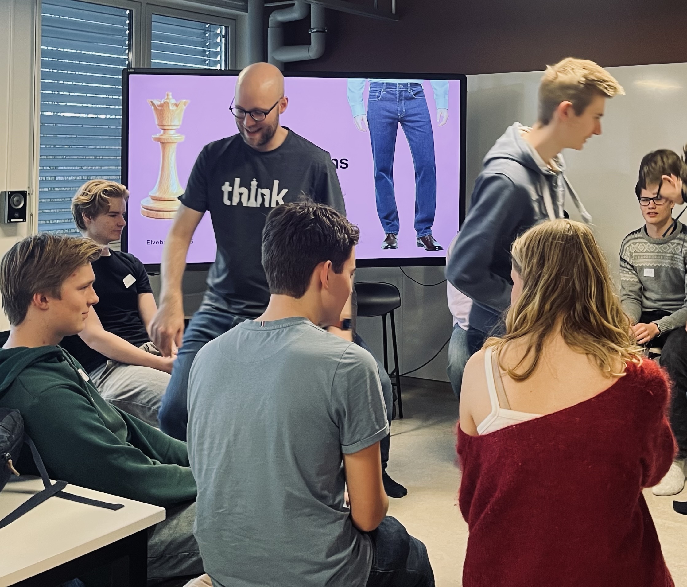 en gruppe mennesker som sitter i et rom