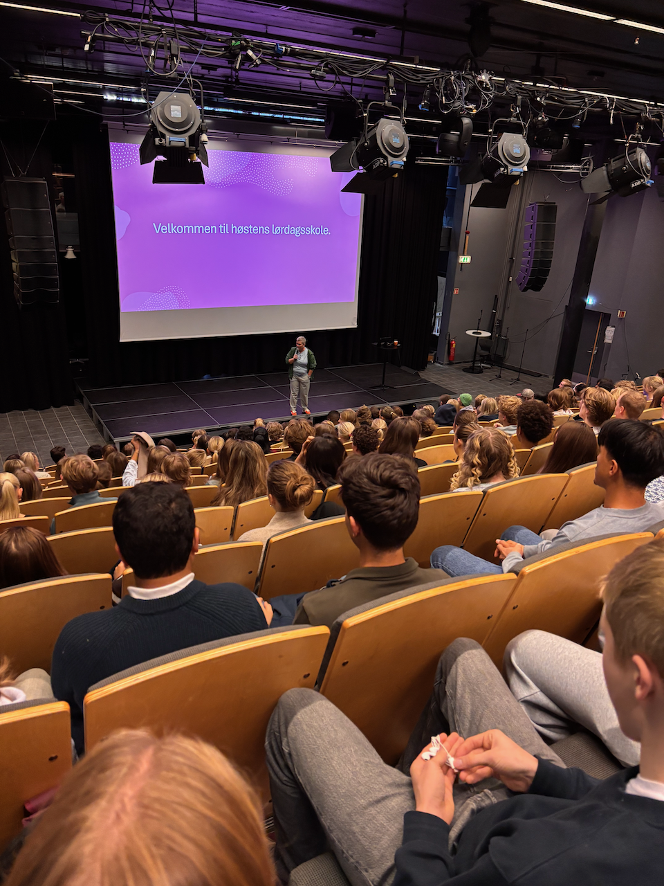 en person som står på en scene foran en folkemengde