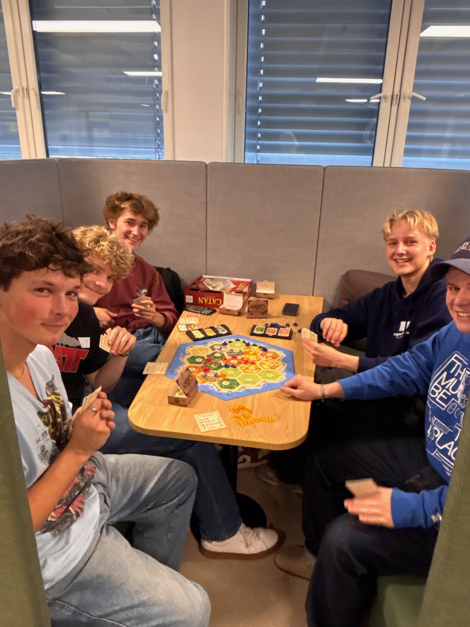 en gruppe mennesker som sitter rundt et bord med en pizza på