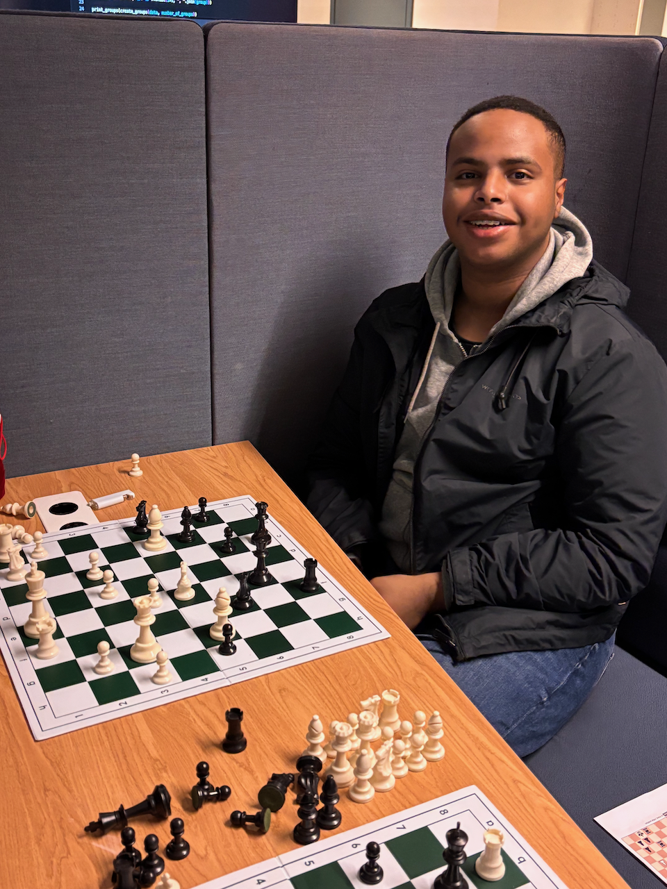 en person som sitter ved et bord med et sjakkbrett og et sjakkbrett