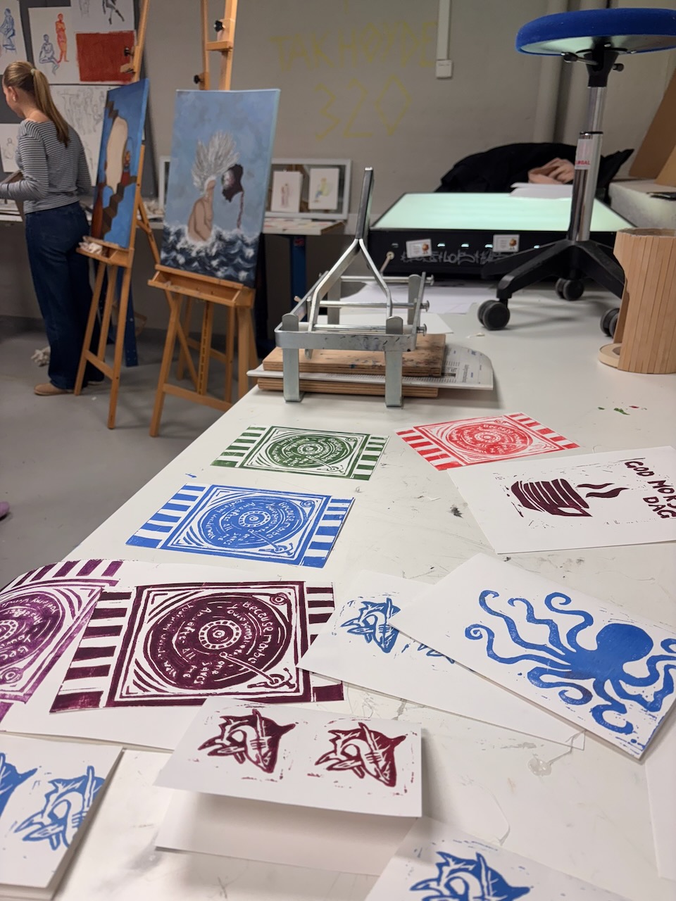 en person som står ved siden av et bord med tegninger på