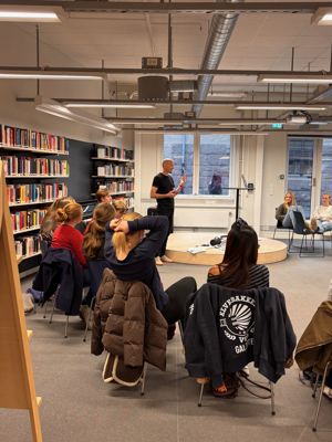 en gruppe mennesker som sitter i et bibliotek