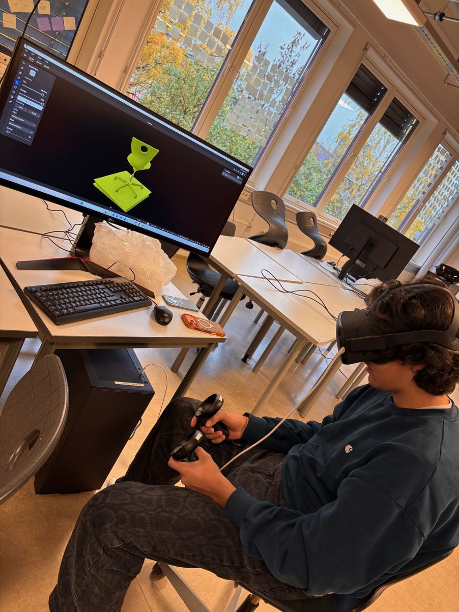 en person som sitter ved et skrivebord med en datamaskin og et stort vindu