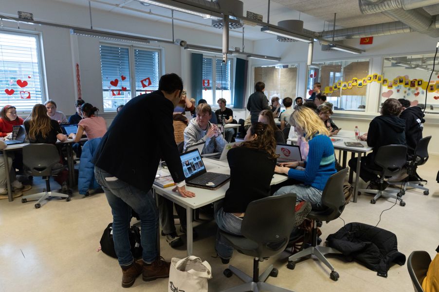 en gruppe mennesker som sitter ved bord med bærbare datamaskiner