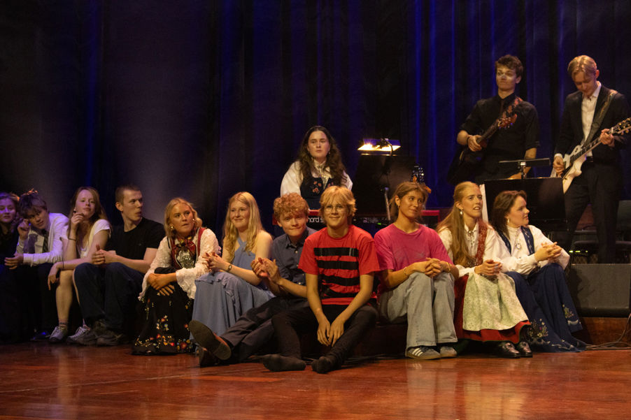 en gruppe mennesker som sitter på en scene