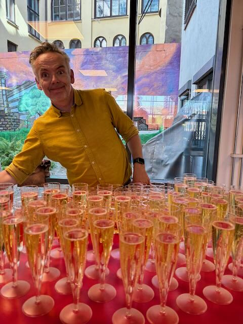 en person som sitter bak et bord med glass med væske