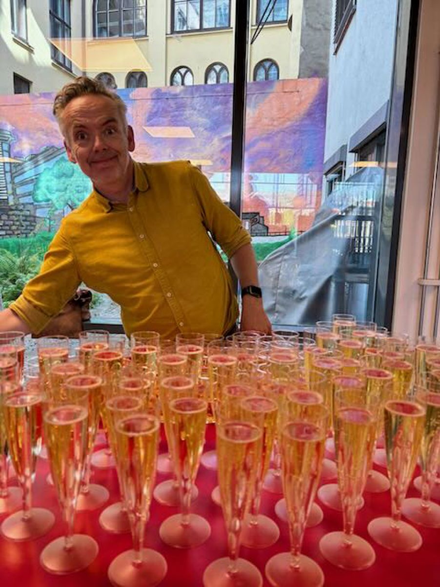 en person som sitter bak et bord med glass med væske