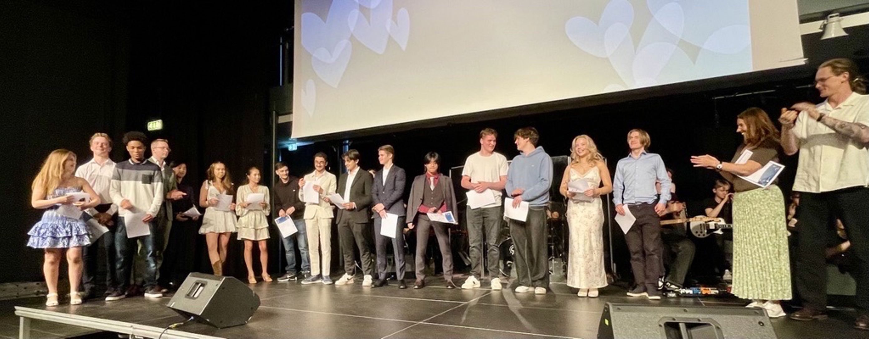 en gruppe mennesker som står foran en skjerm