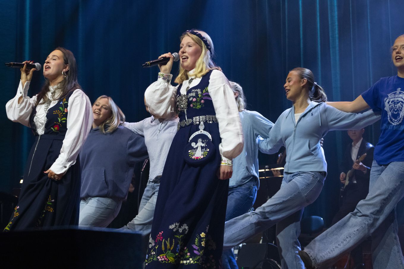 en gruppe mennesker som synger på scenen