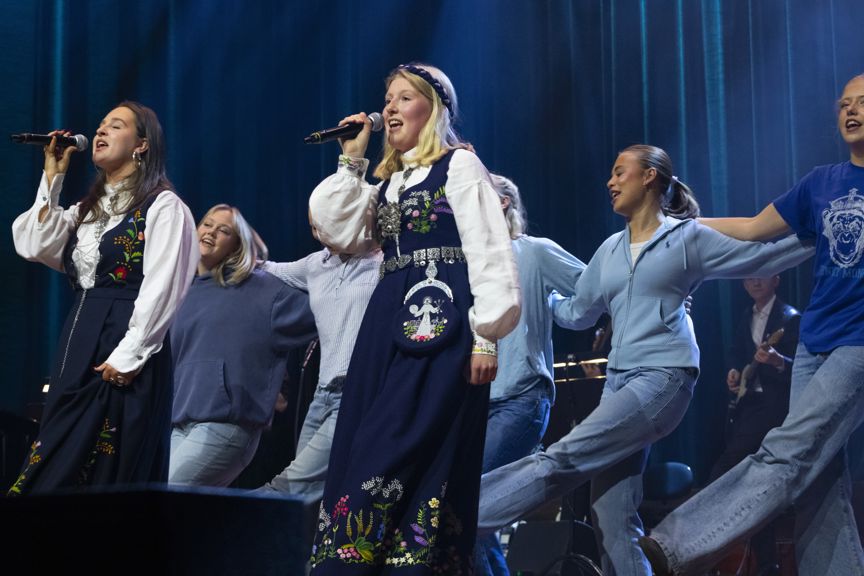 en gruppe mennesker som synger på scenen