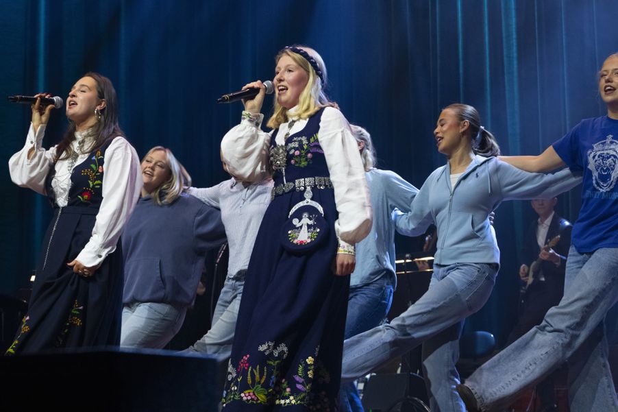 en gruppe mennesker som synger på scenen